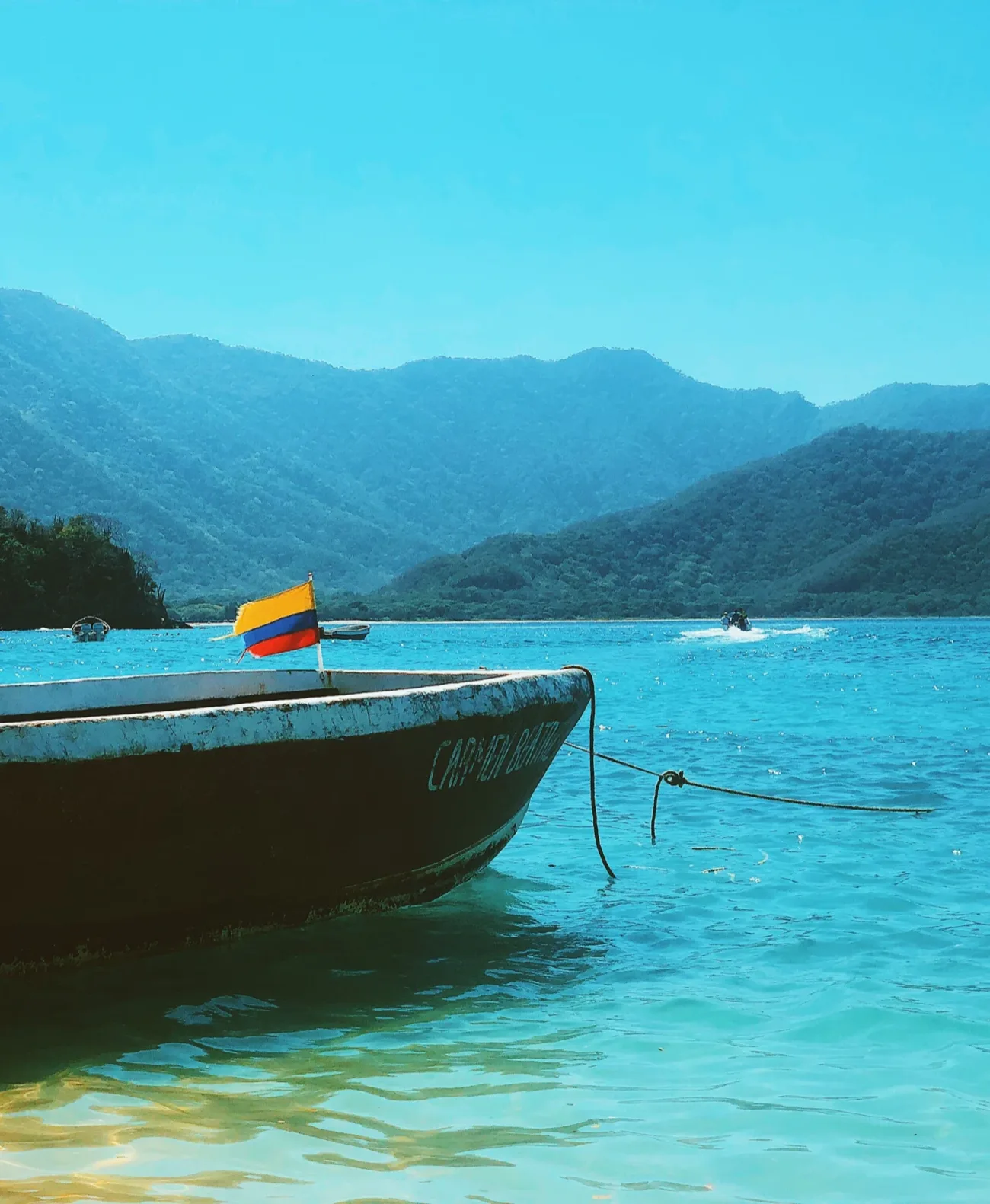 Una lancha con la bandera de Colombia fondeada en el agua turquesa de Bahía Málaga, en el Pacífico colombiano